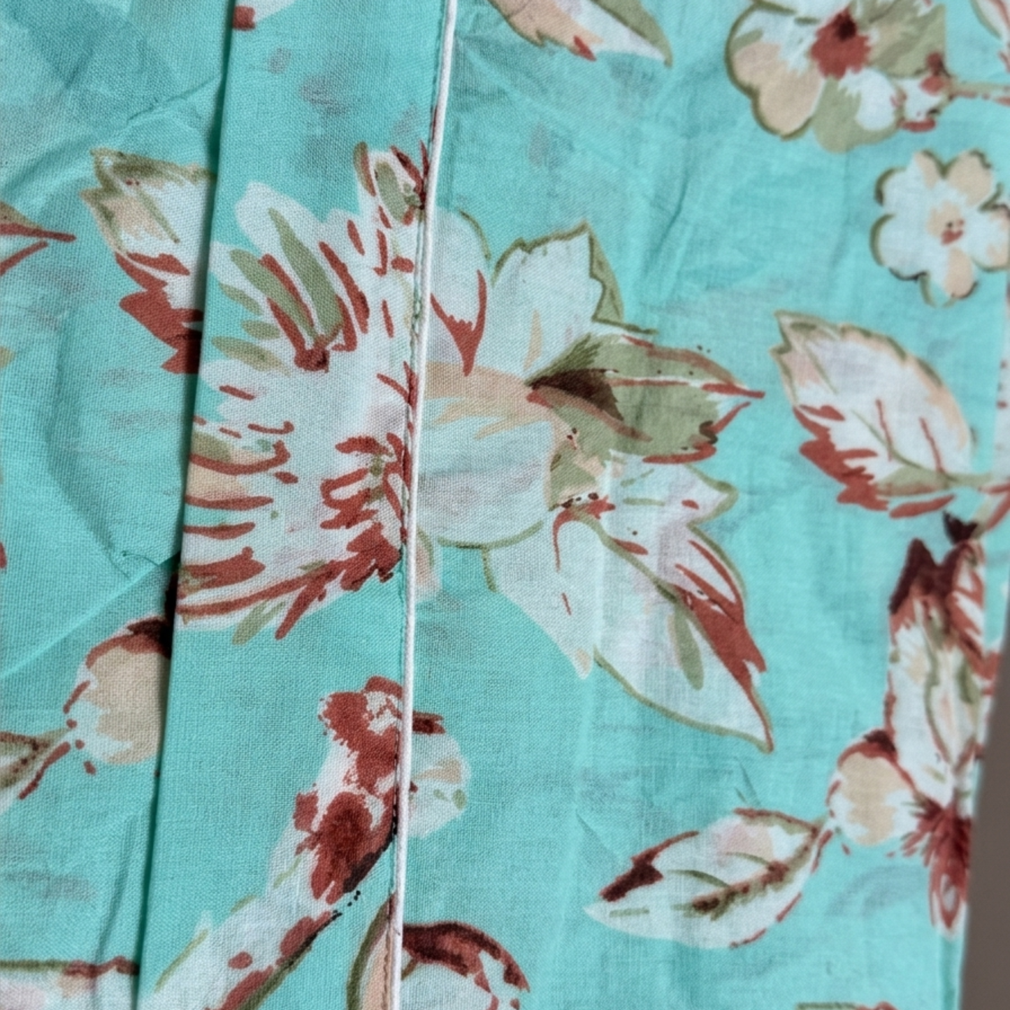 Floral fabric with red and white flowers on a turquoise background