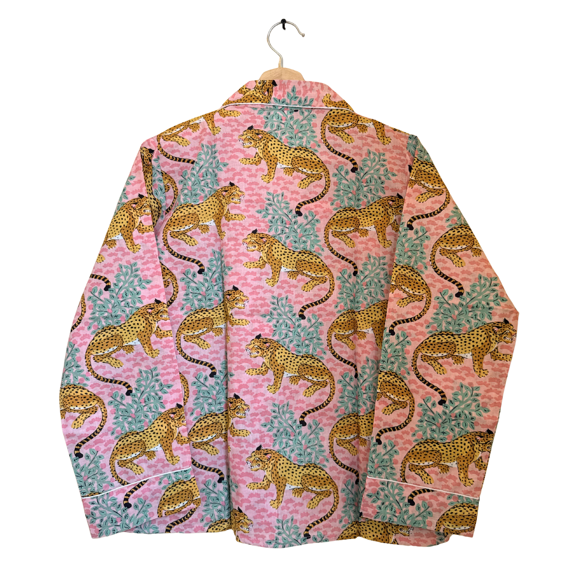 Pink shirt with leopard pattern on a hanger against a white background